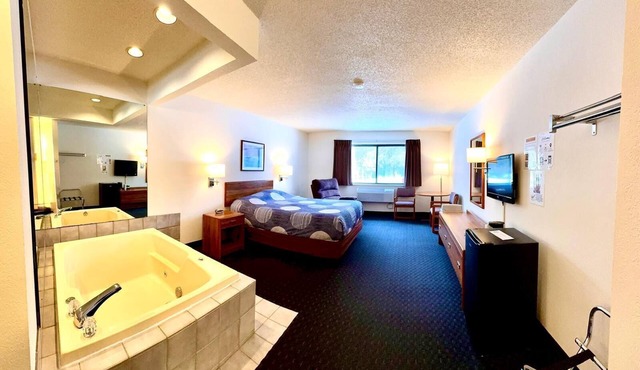 One queen bed, private bathroom, two-person whirlpool tub, mini fridge, and single-serve coffee maker.